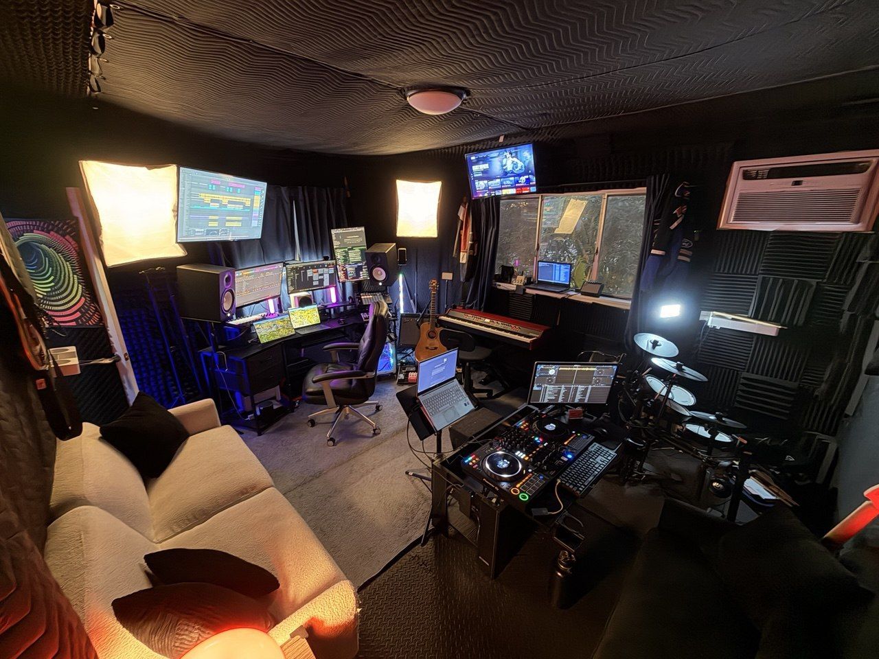 Full studio panorama, couch, DJ deck, drums, DAW screens, colorful psychedelic art